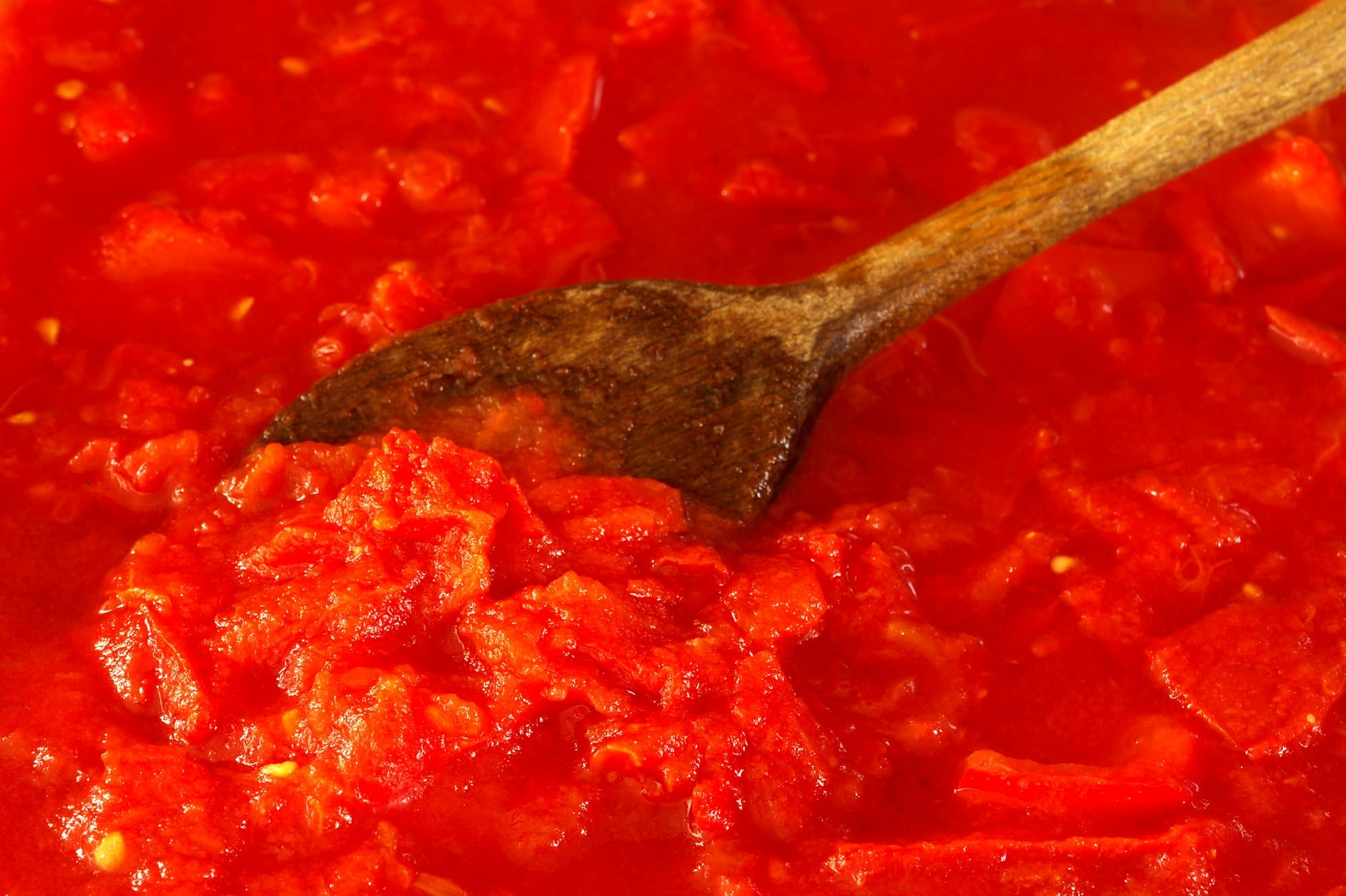Fresh authentic tomato sauce being stirred in a pan